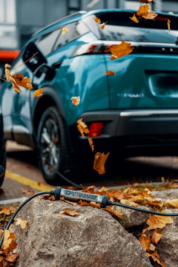 Auto verde eléctrico en un paisaje otoñal con hojas de otoño cayendo. Ilustra la sostenibilidad y la movilidad eléctrica.